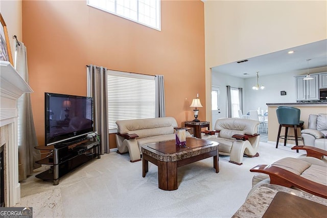 carpeted living room with a towering ceiling and a high end fireplace