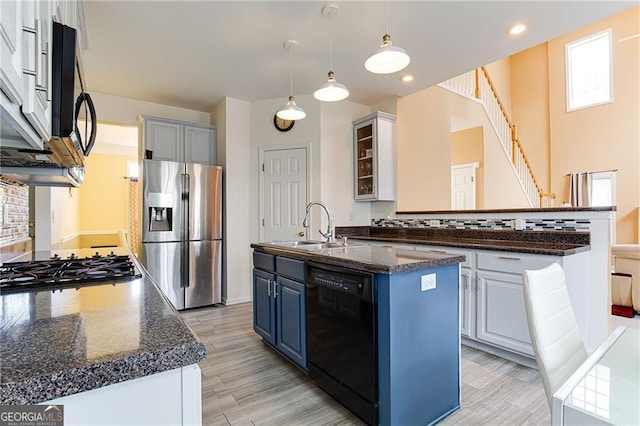 kitchen featuring blue cabinets, sink, white cabinetry, appliances with stainless steel finishes, and a kitchen island