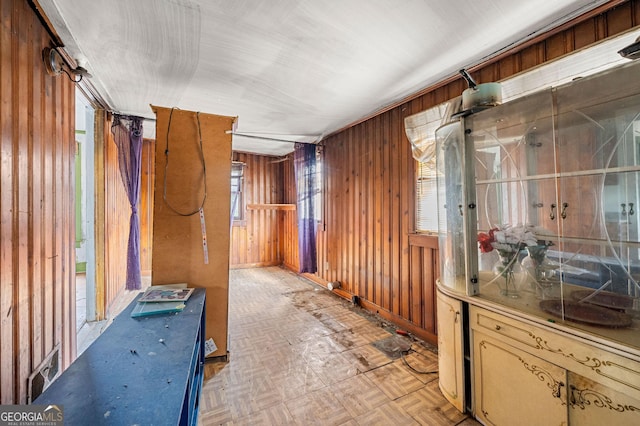 hallway featuring wooden walls and light parquet floors