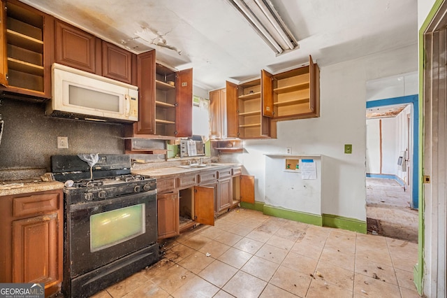 kitchen featuring tasteful backsplash, black range with gas cooktop, sink, and light tile patterned floors