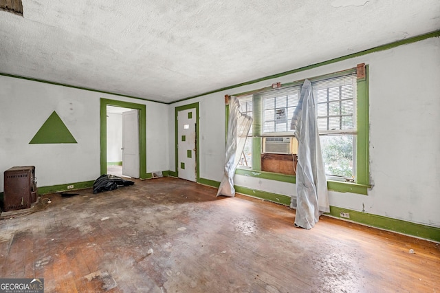 interior space with cooling unit, wood-type flooring, and a textured ceiling