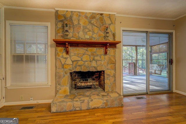 living room featuring hardwood / wood-style flooring, a fireplace, ornamental molding, and ceiling fan