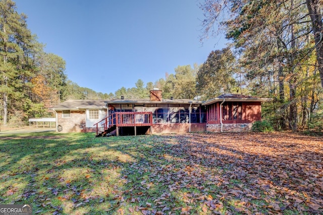 back of house featuring a wooden deck, a sunroom, and a yard