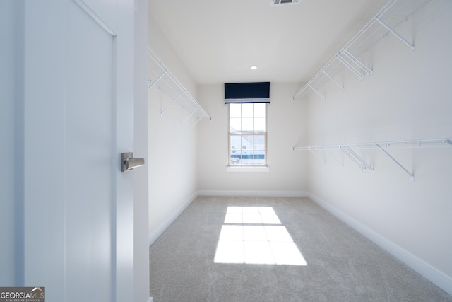 walk in closet featuring light carpet