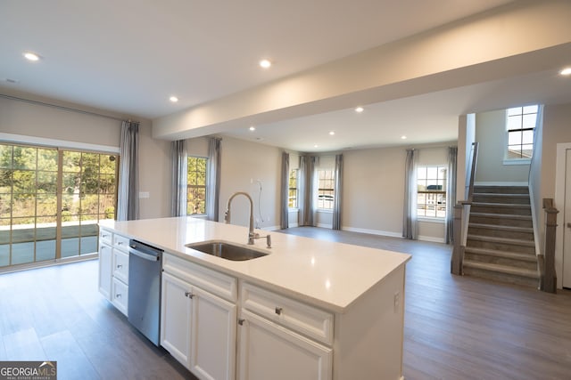 kitchen with hardwood / wood-style floors, dishwasher, an island with sink, sink, and white cabinets