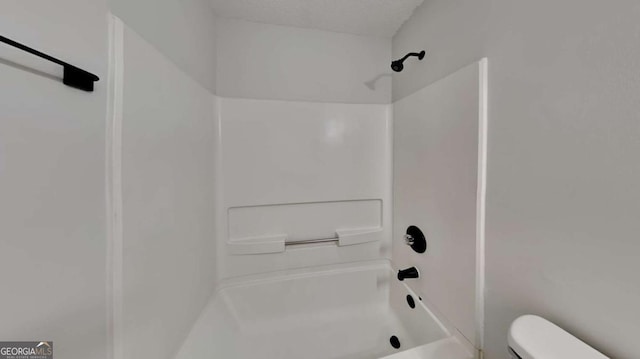 bathroom featuring  shower combination, toilet, and a textured ceiling