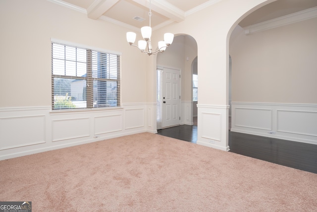 carpeted empty room featuring crown molding, coffered ceiling, a chandelier, and beamed ceiling