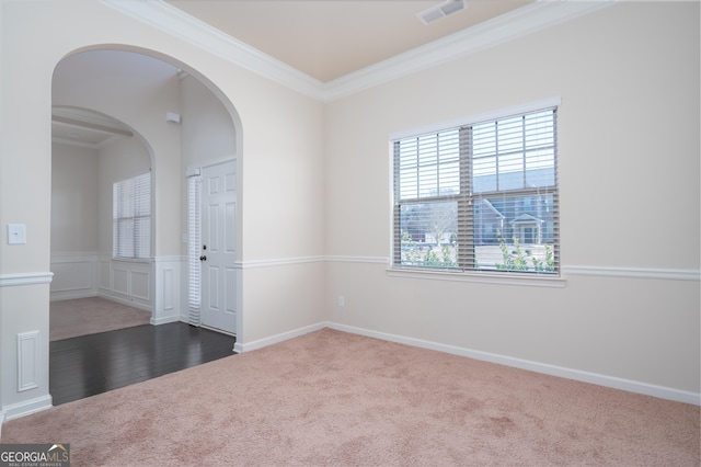 carpeted spare room featuring crown molding