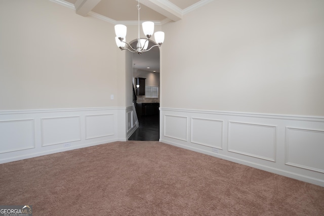 spare room featuring an inviting chandelier, dark carpet, crown molding, and beamed ceiling