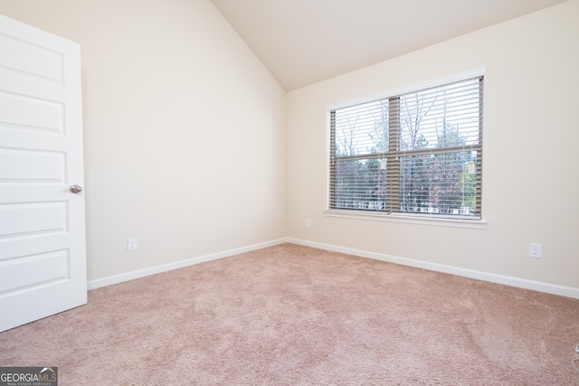 unfurnished room featuring light colored carpet and vaulted ceiling