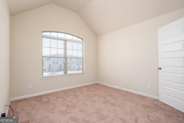 carpeted spare room featuring lofted ceiling