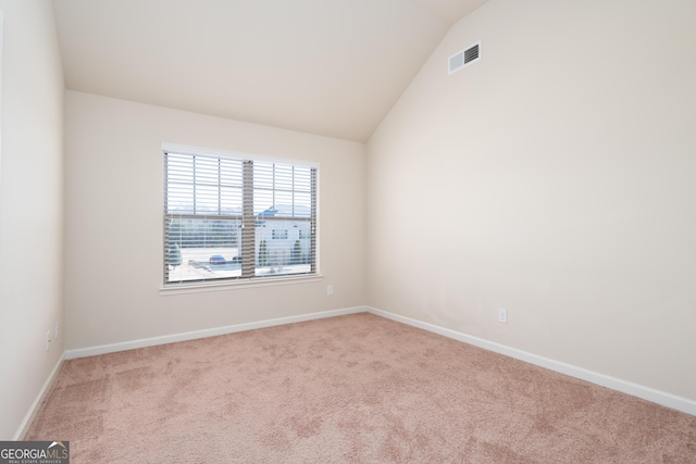 empty room with lofted ceiling and light carpet