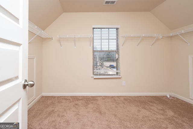 spacious closet with vaulted ceiling and light carpet