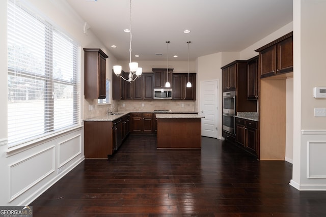 kitchen with a kitchen island, sink, hanging light fixtures, stainless steel appliances, and plenty of natural light