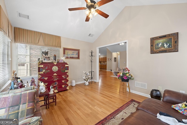 living room with high vaulted ceiling, hardwood / wood-style floors, and ceiling fan