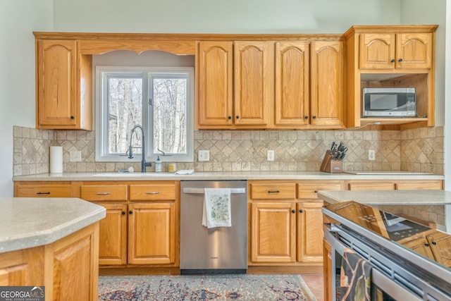 kitchen with stainless steel appliances, sink, and backsplash