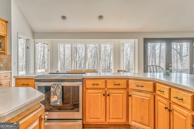 kitchen with lofted ceiling, a healthy amount of sunlight, and backsplash