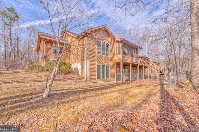 back of property with a wooden deck and a sunroom