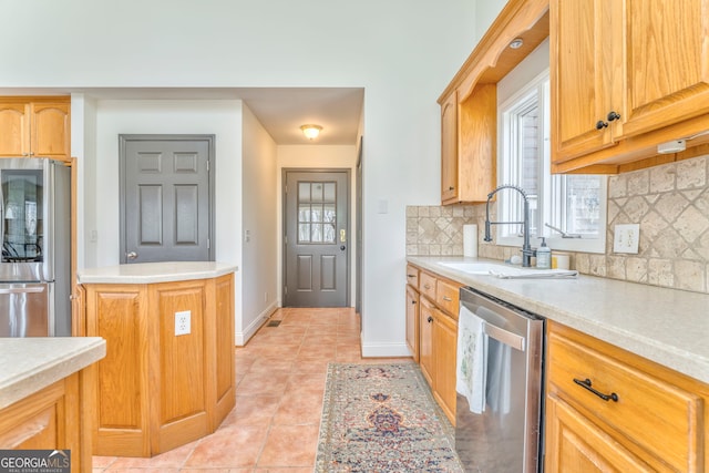 kitchen with tasteful backsplash, stainless steel appliances, light tile patterned flooring, and sink