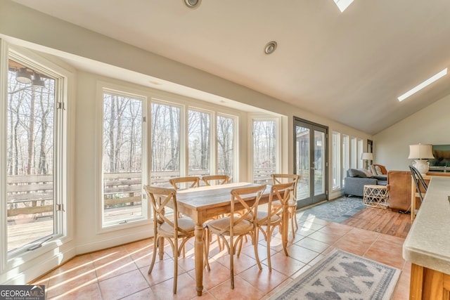 tiled dining area with vaulted ceiling