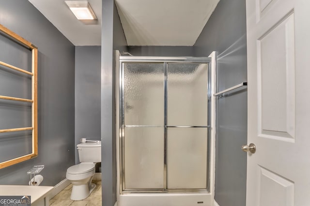 bathroom featuring toilet and a shower with shower door