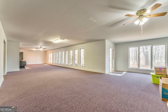 unfurnished living room featuring ceiling fan, a healthy amount of sunlight, and carpet flooring