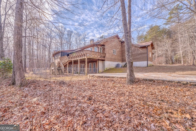 rear view of house featuring a wooden deck