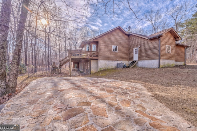 view of property exterior with central AC, a deck, and a patio area