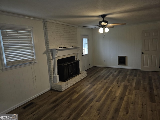 unfurnished living room with dark hardwood / wood-style flooring, heating unit, ornamental molding, and ceiling fan