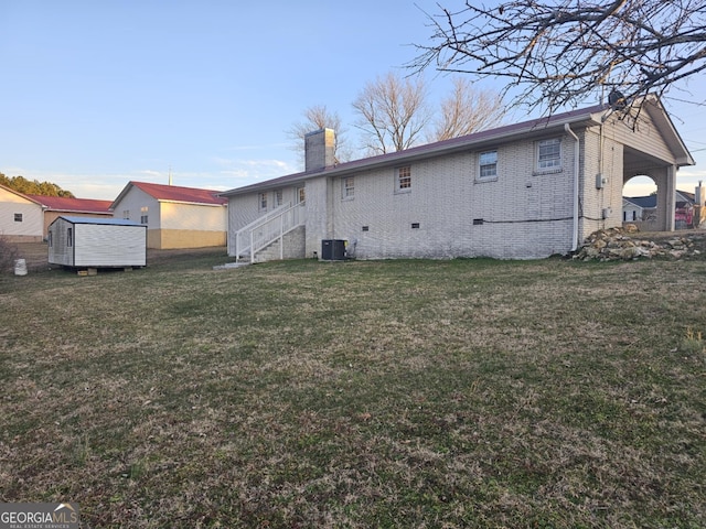 rear view of house featuring a yard and central AC