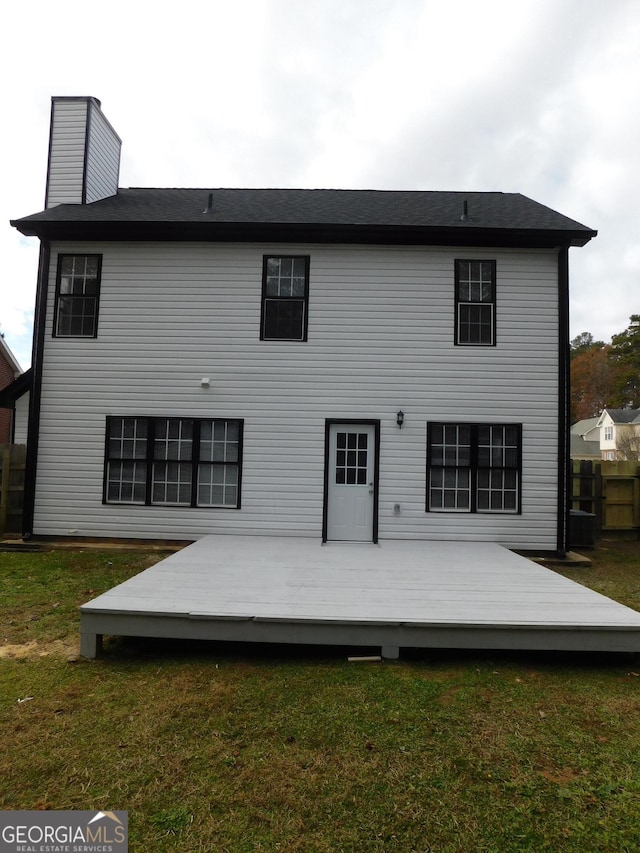 back of house featuring a wooden deck and a yard