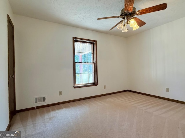 unfurnished room with ceiling fan, light colored carpet, and a textured ceiling