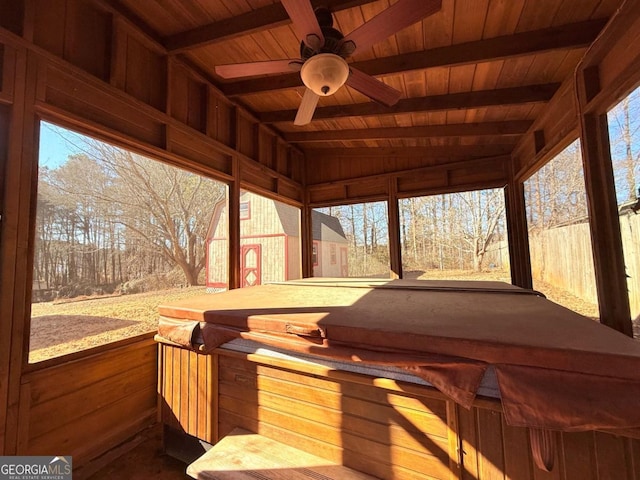 sunroom with vaulted ceiling with beams, a wealth of natural light, wooden ceiling, and ceiling fan