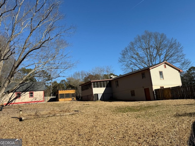 view of property exterior featuring a lawn and a sunroom