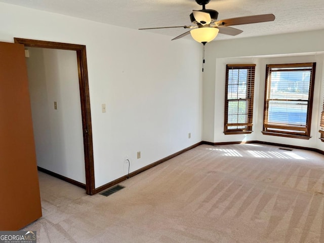 carpeted spare room with ceiling fan