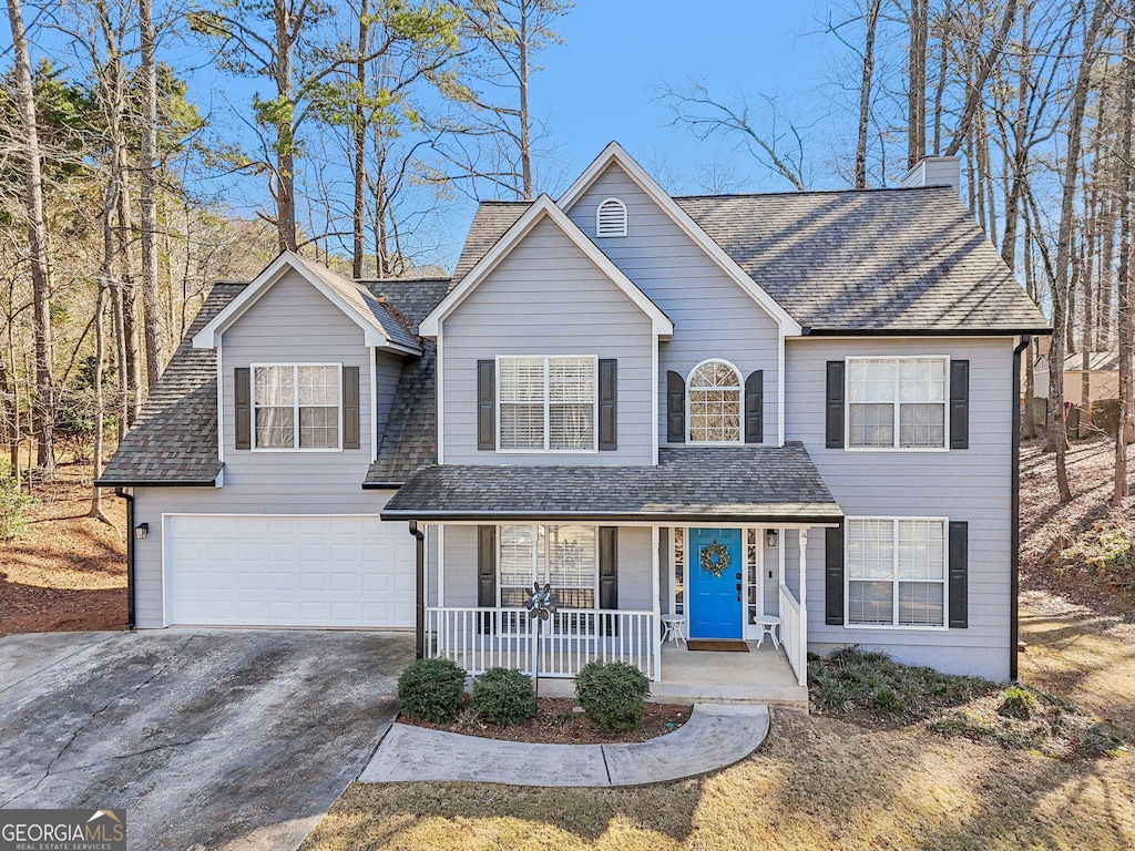 view of property featuring a garage and covered porch