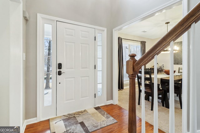 foyer entrance with hardwood / wood-style flooring and a chandelier