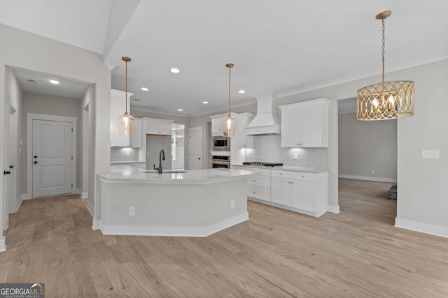 kitchen with premium range hood, gas stovetop, tasteful backsplash, and white cabinets