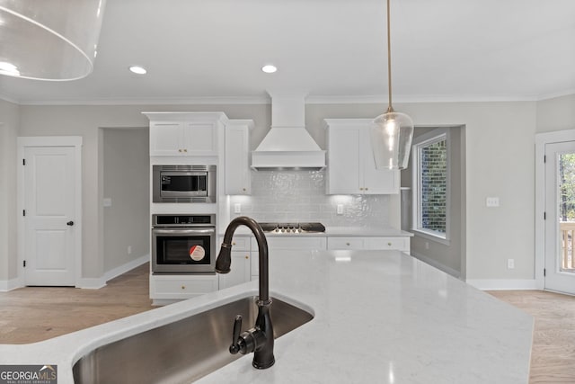 kitchen featuring light stone counters, crown molding, custom exhaust hood, and stainless steel appliances