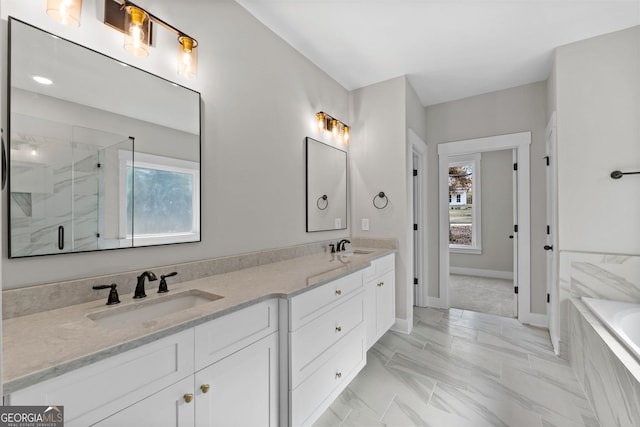 bathroom featuring independent shower and bath, vanity, and a wealth of natural light