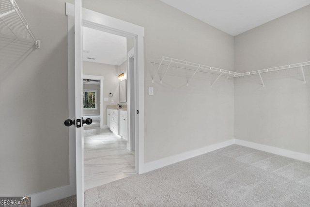 walk in closet featuring light colored carpet