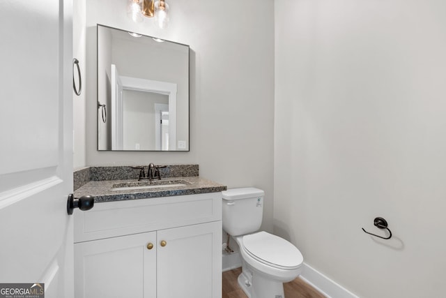 bathroom with vanity, toilet, and wood-type flooring