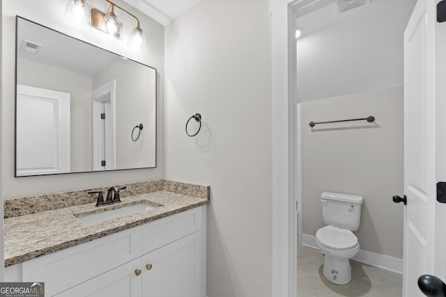 bathroom featuring vanity, tile patterned floors, and toilet