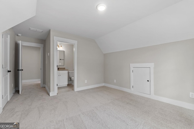 additional living space with vaulted ceiling and light carpet