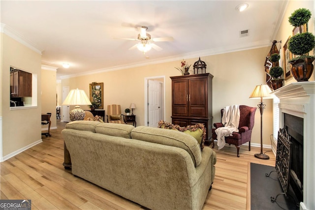 living room featuring crown molding, ceiling fan, and light hardwood / wood-style flooring