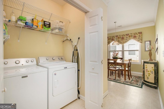 laundry room with washing machine and dryer and crown molding