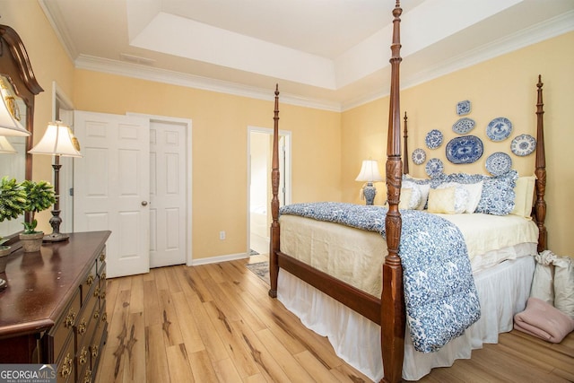 bedroom with a raised ceiling, ornamental molding, and light wood-type flooring