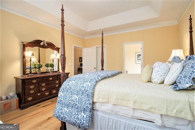 bedroom with light hardwood / wood-style flooring, ornamental molding, and a raised ceiling