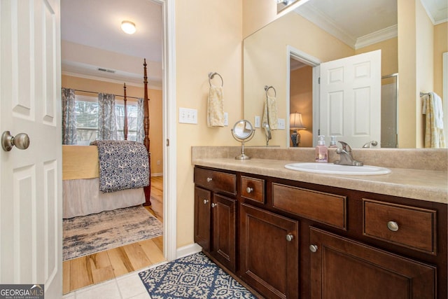 bathroom with ornamental molding, hardwood / wood-style floors, and vanity