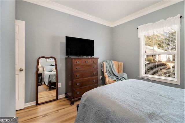 bedroom featuring ornamental molding and light wood-type flooring